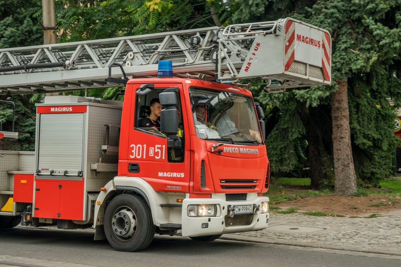 Firetruck with firefighters in Wrocław, Poland. Emergency response vehicle in action outdoors.